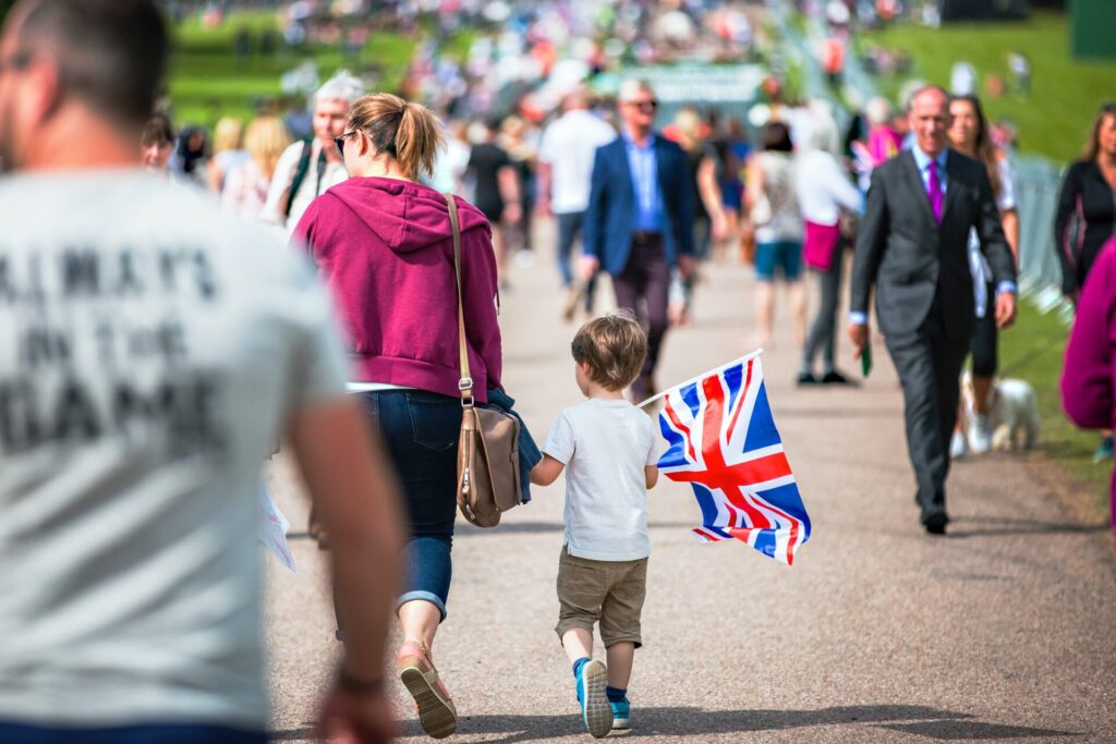 Mère qui se balade avec son enfant. L'enfant porte dans sa main un drapeau de la Grande Bretagne.
